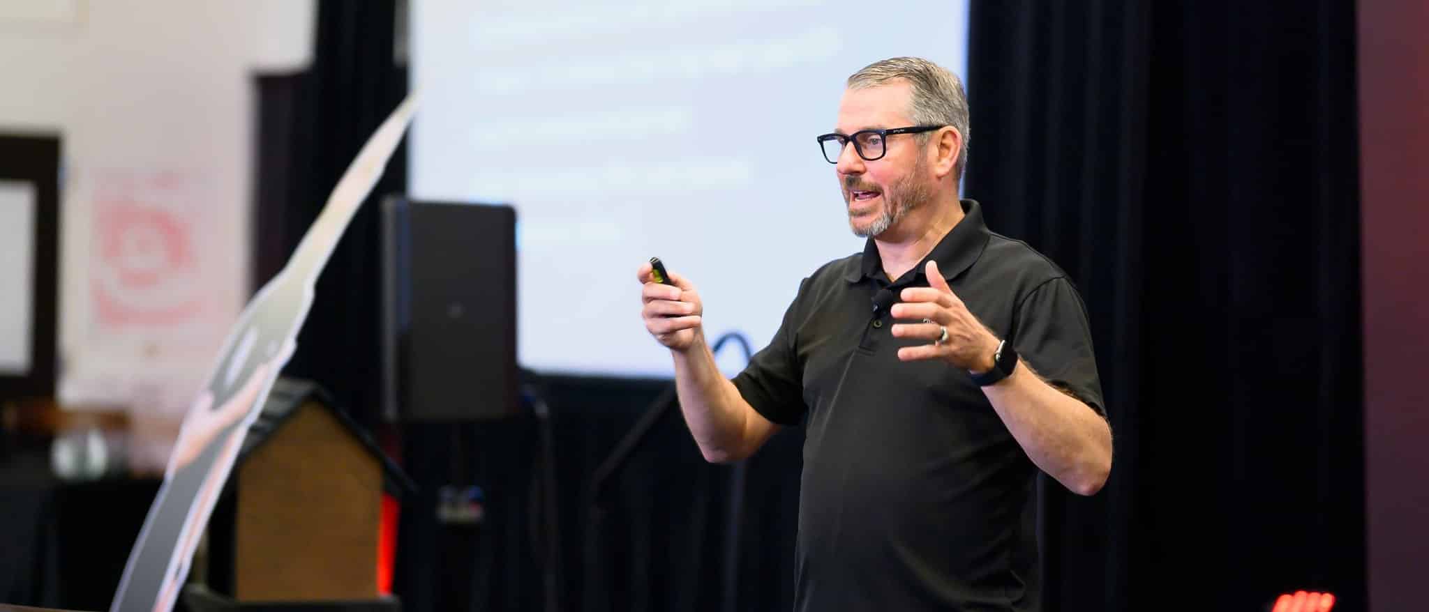 Jerry Macnamara mid-gesture while speaking to a leadership audience