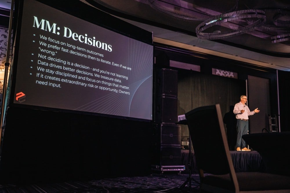 Jerry Macnamara delivering a keynote in front of a framework slide
